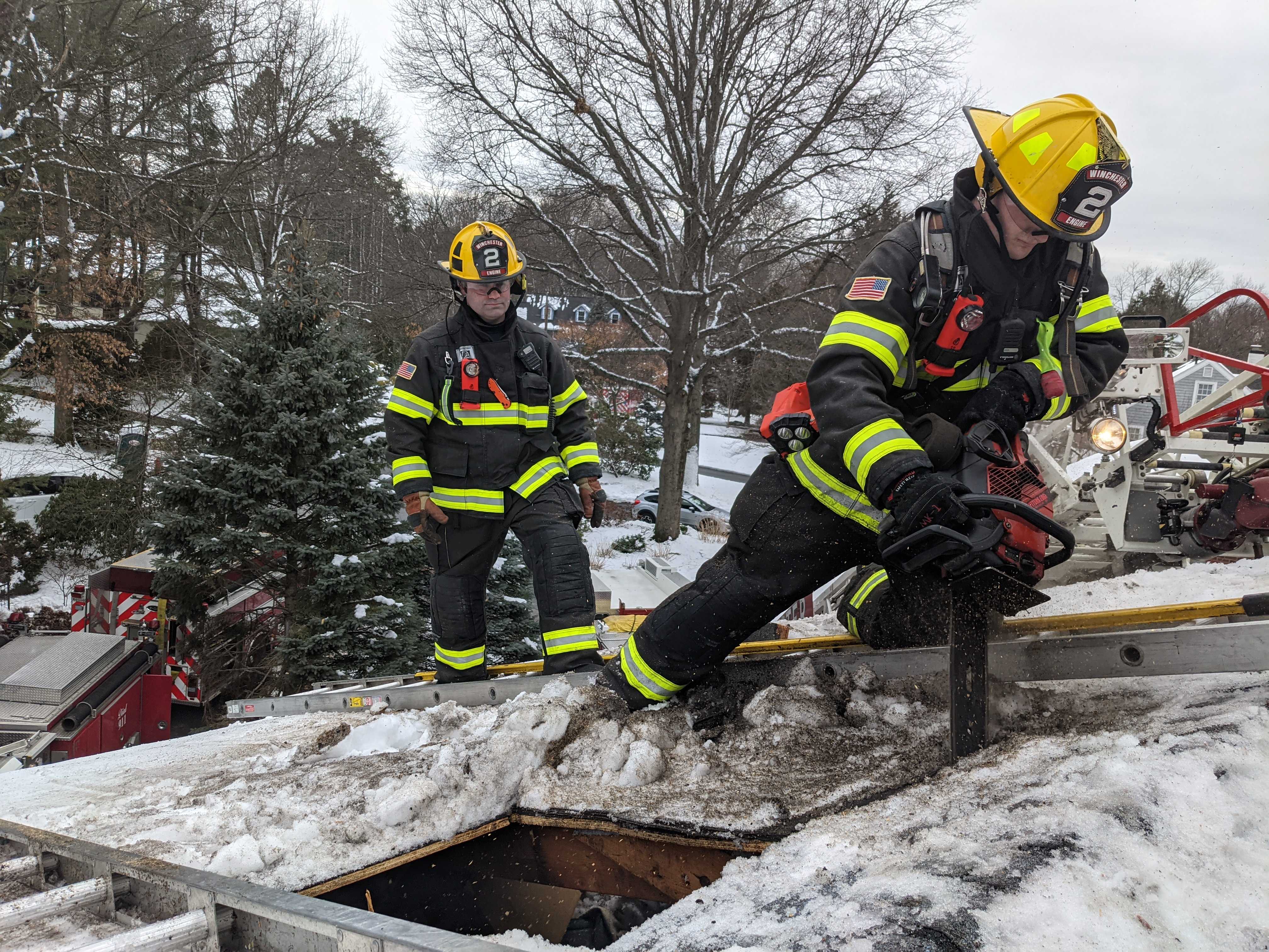 Winchester Firefighters cutting a hole in a roof